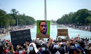 Demonstrators gather on the National Mall to protest racial injustice. An image of George Floyd is held up in front of the Washington Monument.